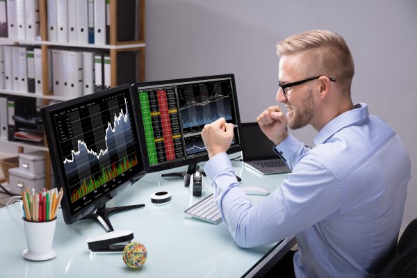 scottrade online stock trading service man happy in front on laptop checking stocks